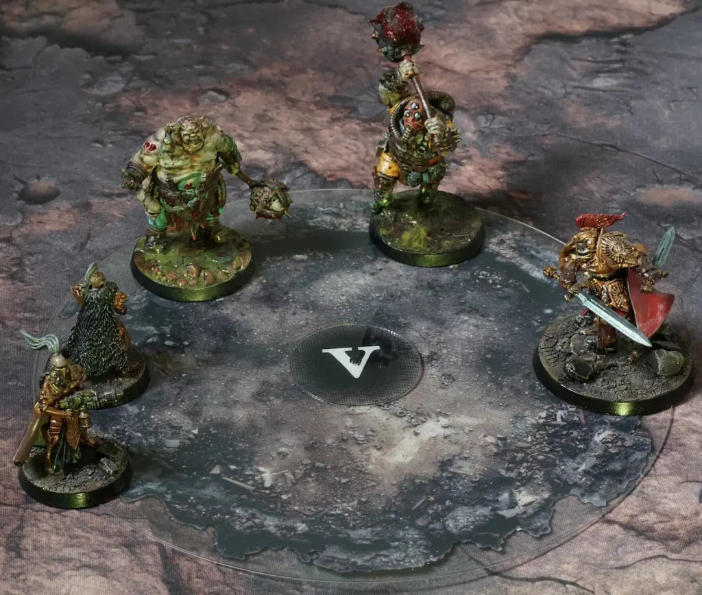 Painted miniatures around a clear circular objective zone