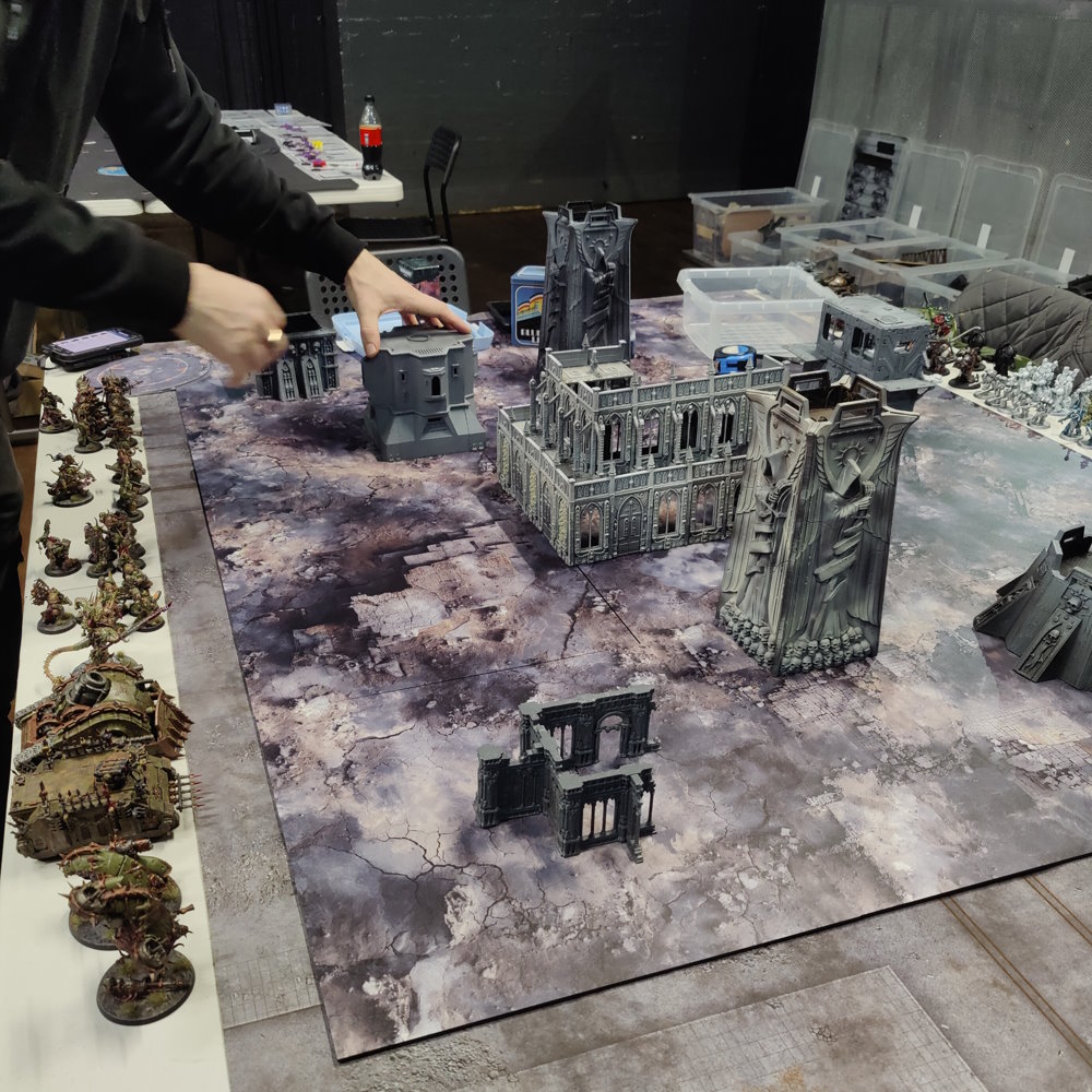 A tabletop battle set up across 2D6 gaming mats
